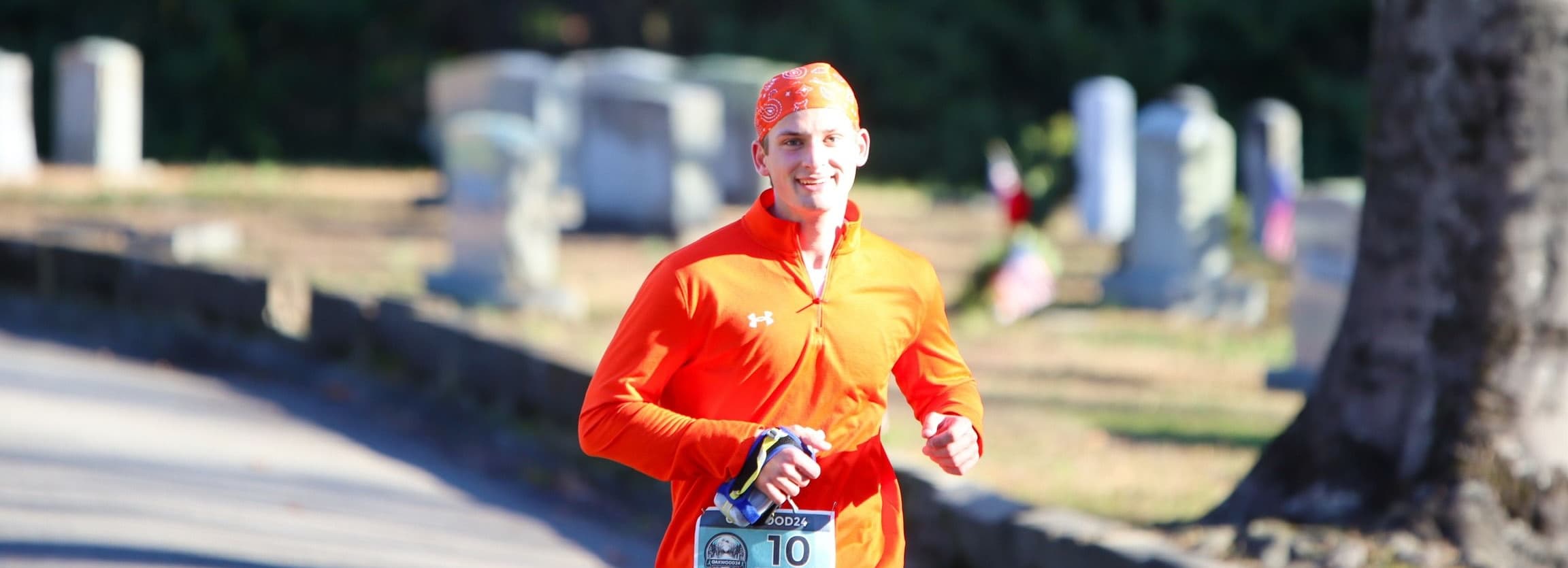 A long distance marathon runner, jogging along a wooded trail.